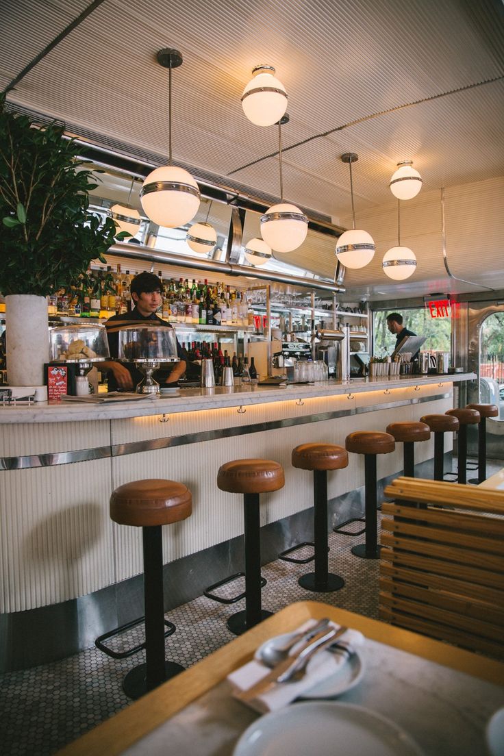 Modern Retro Cafe Design: Sleek Chrome Bar, Warm Lighting, and Inviting Ambiance