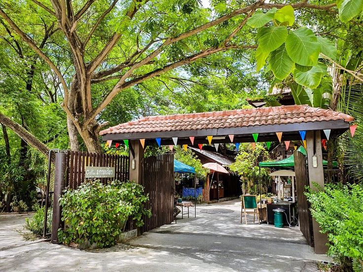 Charming Rustic Cafe Entrance Amidst Lush Greenery and Cozy Outdoor Seating