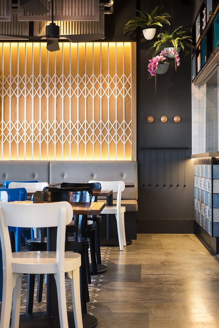 Modern Cafe Design Featuring Geometric Wooden Wall and Vibrant Comfort Elements