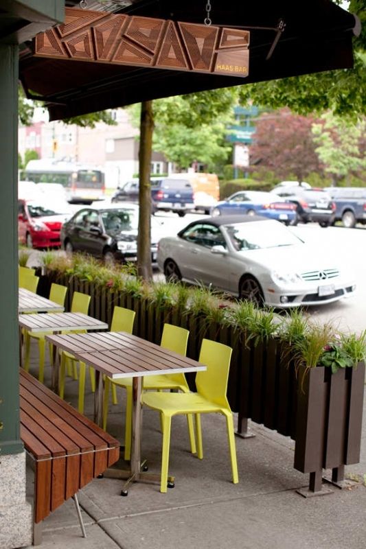 Modern Cafe Design with Inviting Outdoor Seating and Lush Greenery Enhances Communal Atmosphere