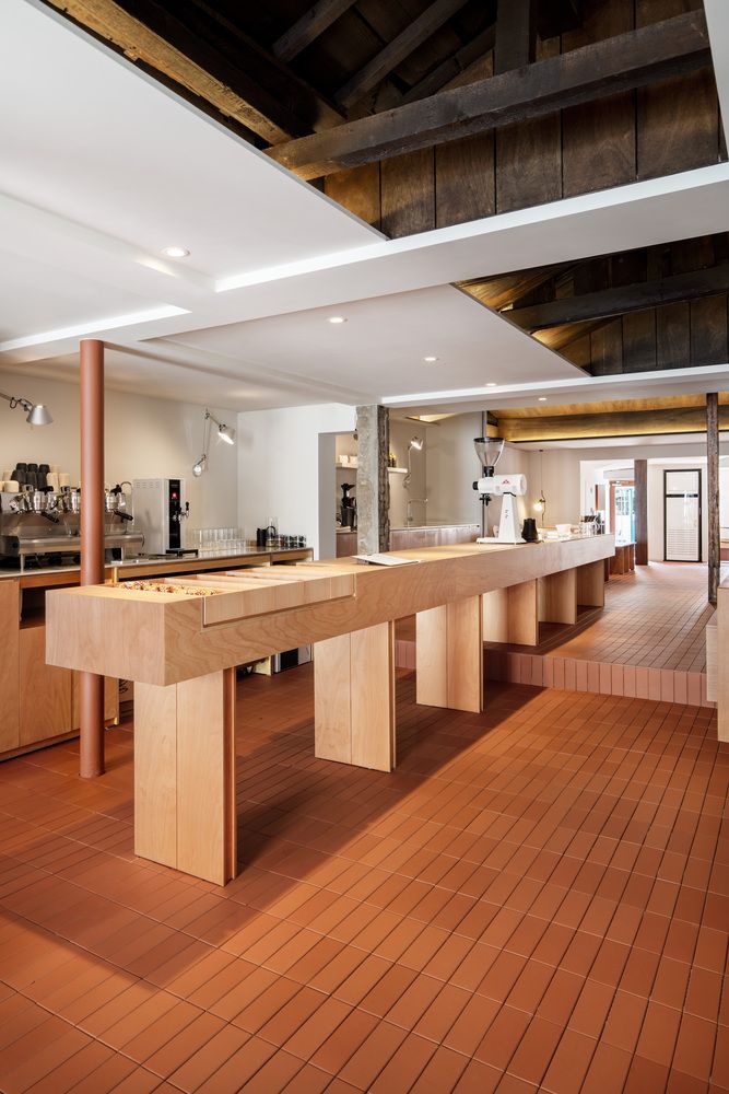 Inviting Minimized Cafe Design with a Striking Wooden Counter and Open Beamed Ceiling