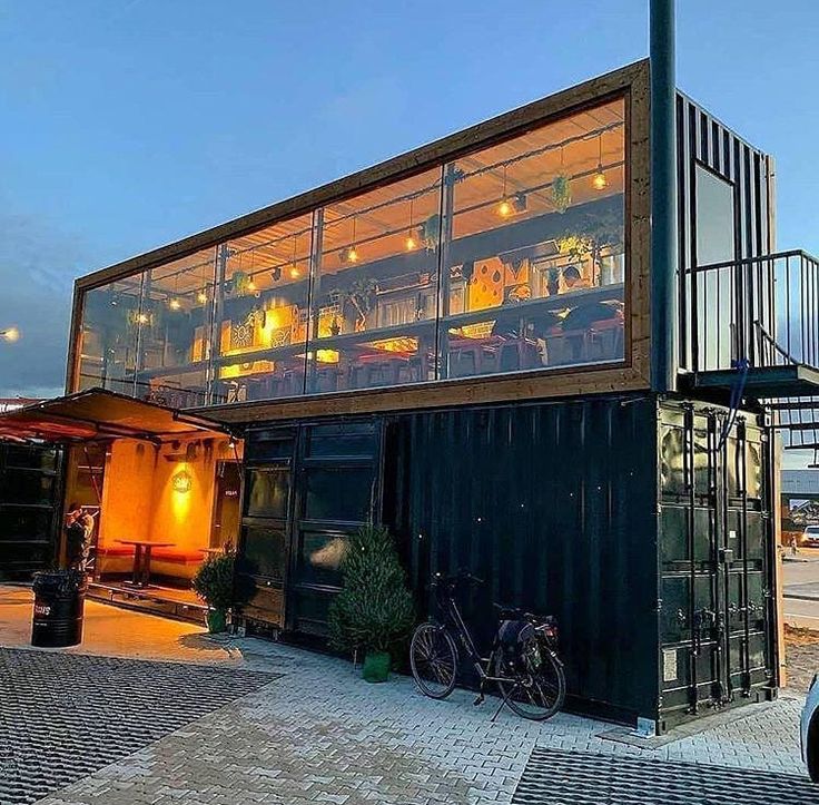 Modern Industrial Cafe Design: Inviting Two-Level Shipping Container Structure with Panoramic Views and Vibrant Ambiance