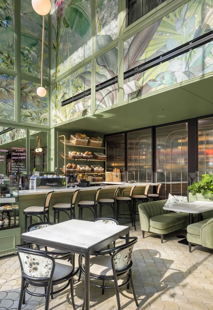 Inviting Cafe Design Embraces Nature and Modern Aesthetics with Botanical Murals and Soothing Green Palette