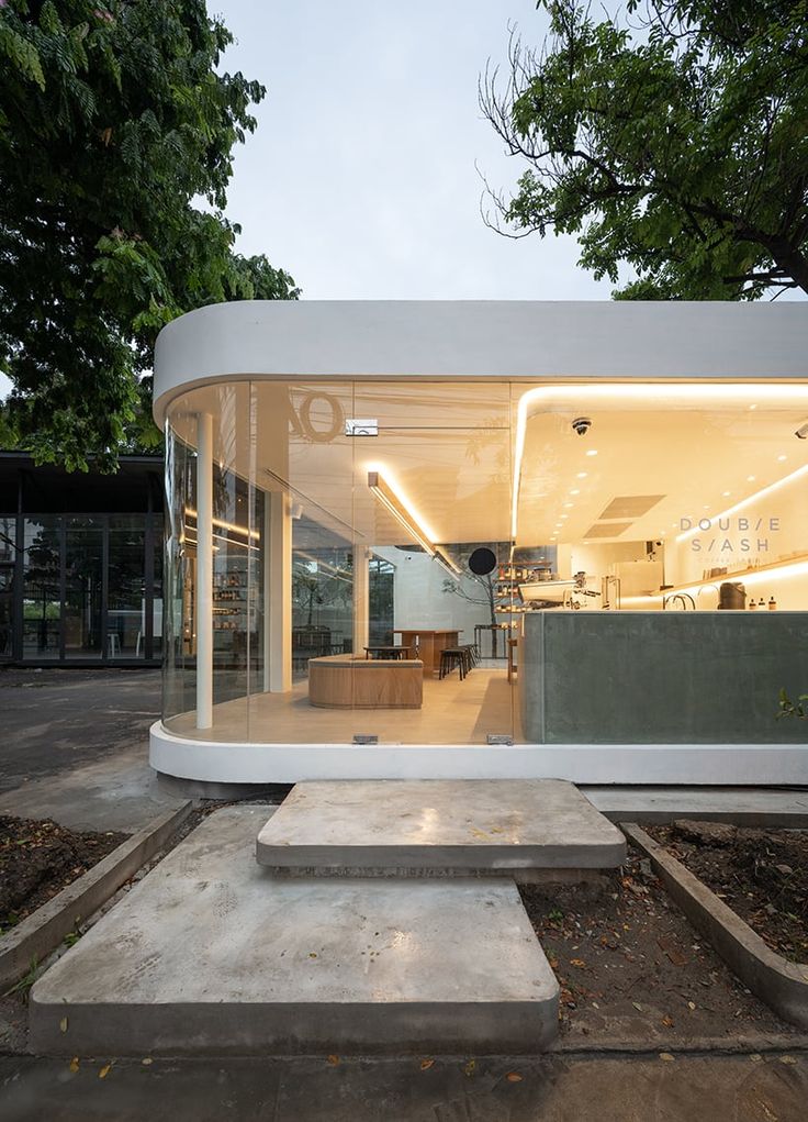 Modern Cafe Boasts Inviting Design with Curved Facade and Natural Light