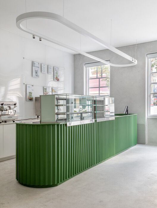 Modern Cafe Design: A Vibrant Green Counter and Minimalist Aesthetic Create an Inviting Atmosphere