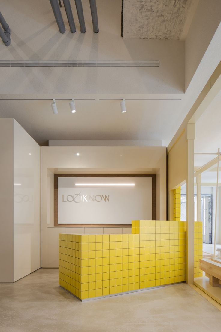 Modern Minimalist Cafe Design with Vibrant Yellow Reception and Airy Atmosphere