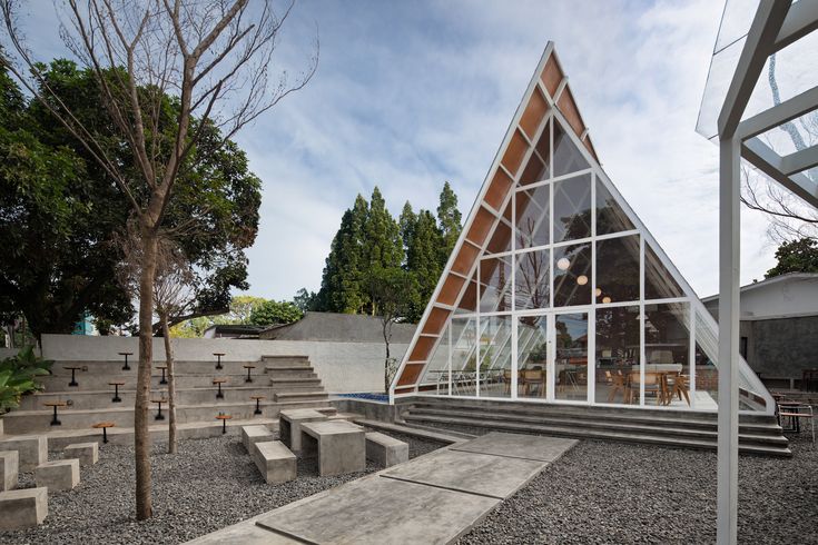 Modern Triangular Cafe Design: A Harmonious Blend of Glass, Wood, and Nature