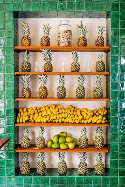 Vibrant Cafe Design Features Fresh Fruit Display Against Green Tiles for a Tropical Atmosphere