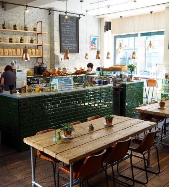 Vibrant Cafe Design: A Warm and Inviting Space with Green Accents and Communal Atmosphere