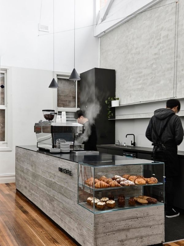 Modern Minimalist Cafe Design: Bright, Airy Space with Concrete Counter and Welcoming Atmosphere