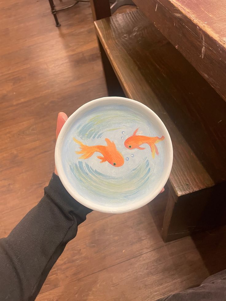 Artistic Ceramic Bowl Showcasing Serene Goldfish Scene Adds Whimsy to Cafe Ambiance