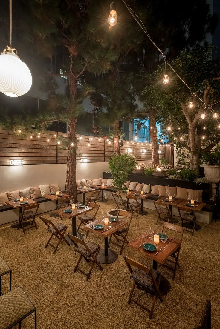 Cozy Cafe Design: Inviting Outdoor Space with Ambient Lighting and Natural Backdrop