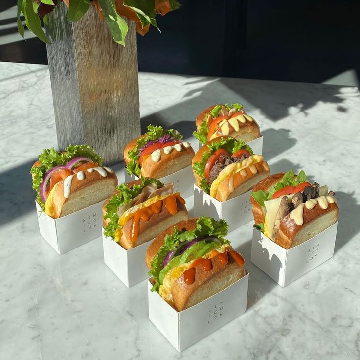 Gourmet Hot Dogs Elegantly Displayed in Minimalist Packaging on a Marble Table