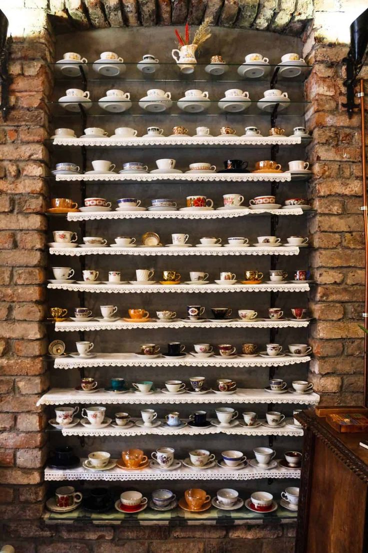 Charming Cafe Design Showcasing Vintage Teacups Against Rustic Brick Wall