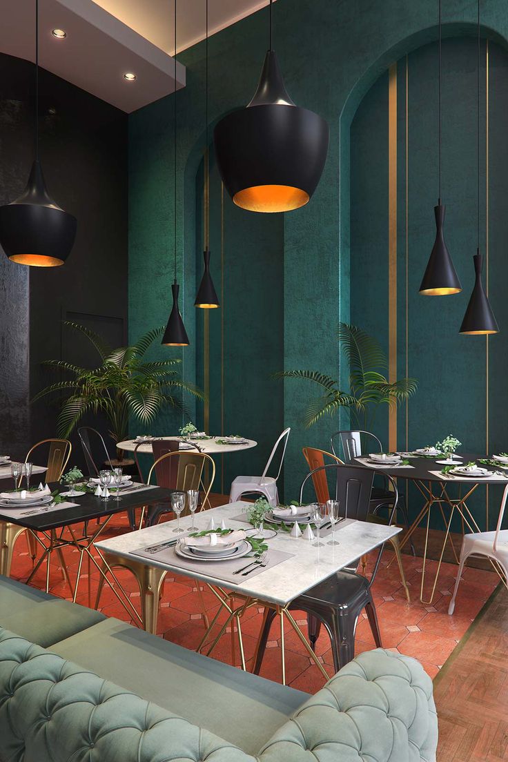 Elegant Cafe Design with Rich Green Walls, Stylish Lighting, and Inviting Decor