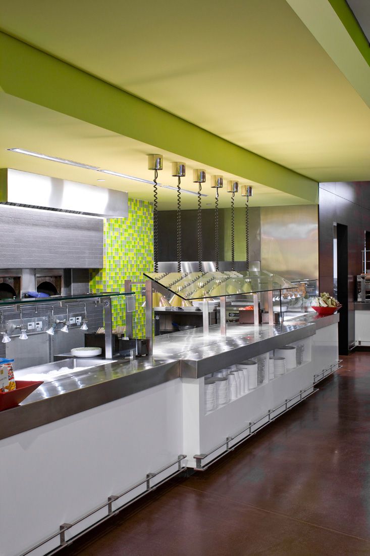 Modern Cafe Design: Sleek Stainless Steel Counter, Vibrant Green Ceiling, and Colorful Tiled Wall Create a Welcoming Atmosphere