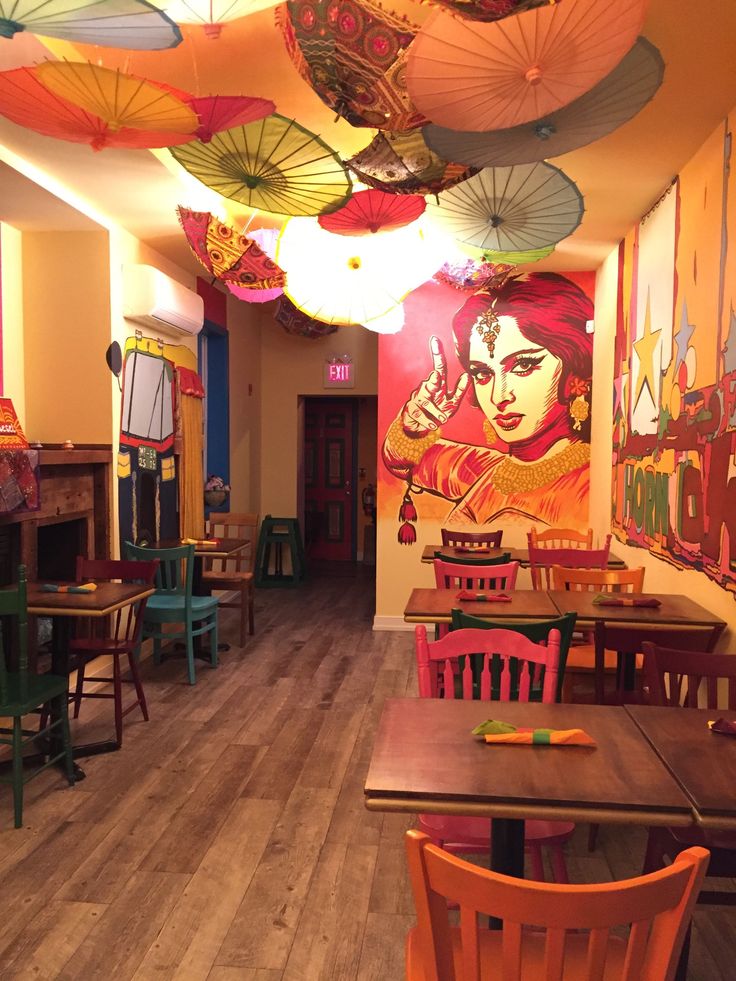 Vibrant Cafe Design Featuring Colorful Umbrellas and Expressive Murals Creates a Unique Dining Experience