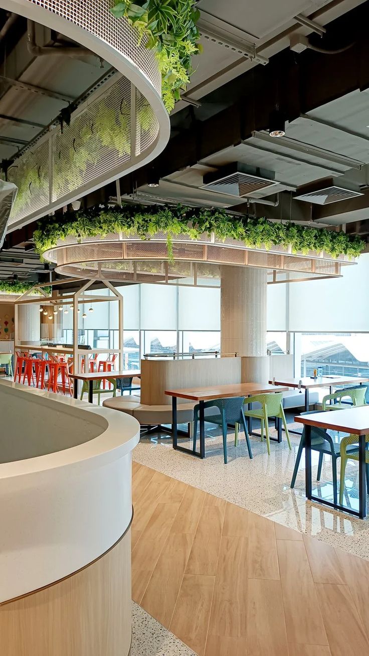 Modern Cafe Design: A Lush, Inviting Space with Colorful Seating and Abundant Natural Light