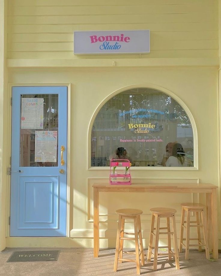 Charming cafe design showcases a warm yellow facade with a striking blue door, inviting ambiance, and cozy interior for socializing