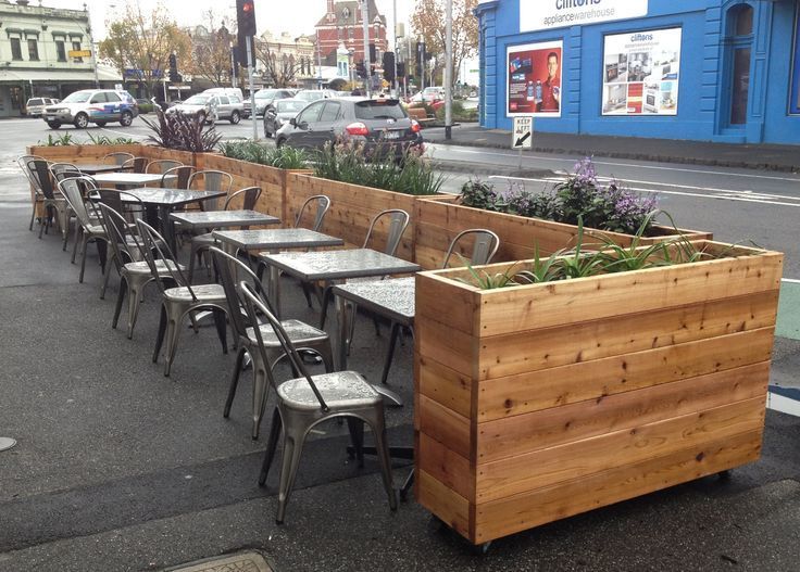 Cozy Outdoor Cafe Design with Wooden Planters and Modern Metal Seating