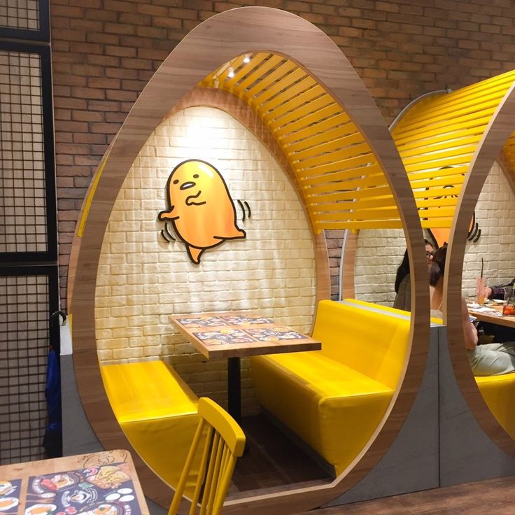 Playful Cafe Design Featuring Egg-Shaped Booths and Whimsical Artwork for a Cozy Dining Experience