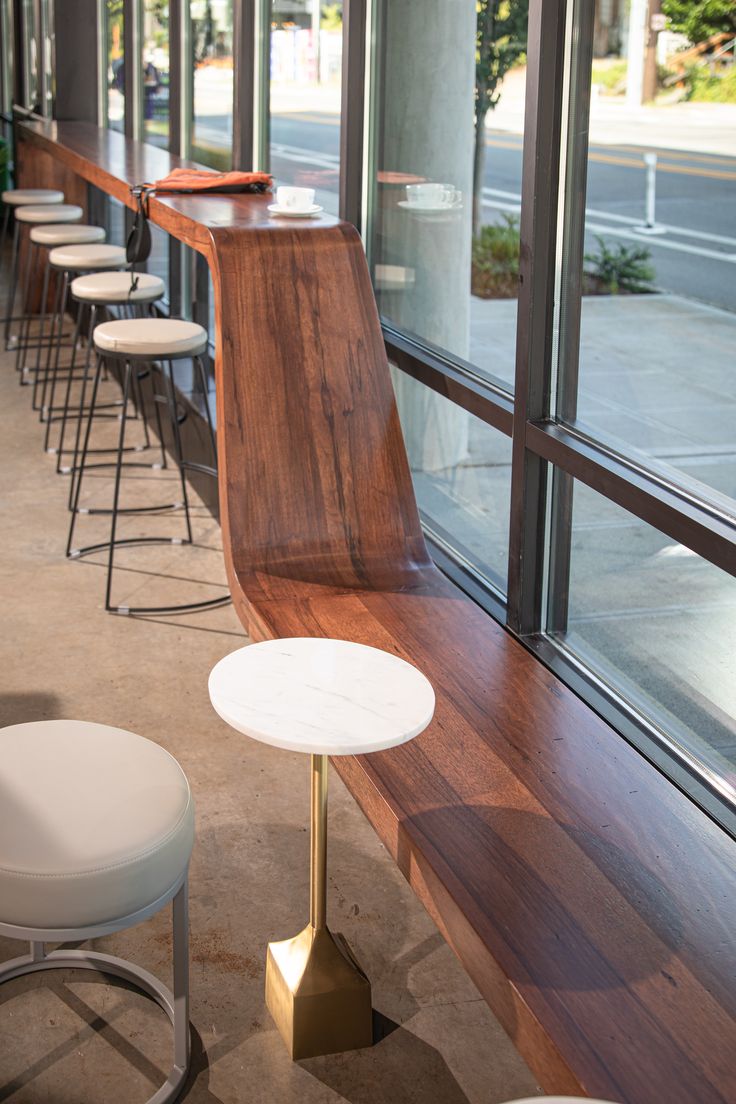 Sleek Cafe Design Blends Curved Wood Seating, Natural Light, and Elegant Accents