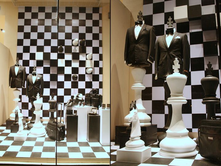 Dynamic Monochromatic Checkerboard Display with Elegant Mannequins and Whimsical Chess Piece Pedestals