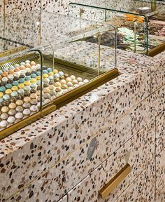 Vibrant Cafe Design Blends Terrazzo Countertops and Elegant Brass Accents for an Inviting Ambiance