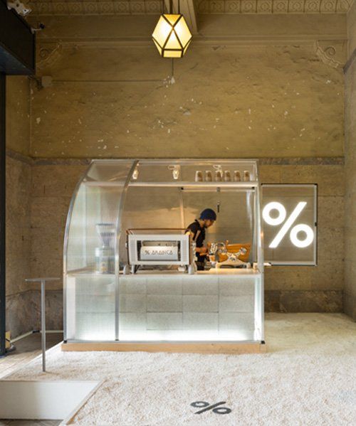 Modern Minimalist Cafe Design: A Sleek Glass Barista Station and Inviting Ambiance