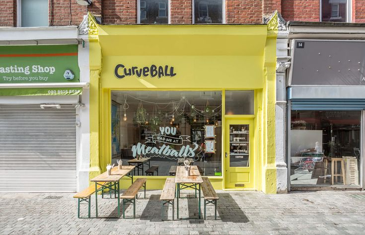 Cheerful Cafe Boasts Vibrant Yellow Exterior and Inviting Communal Atmosphere