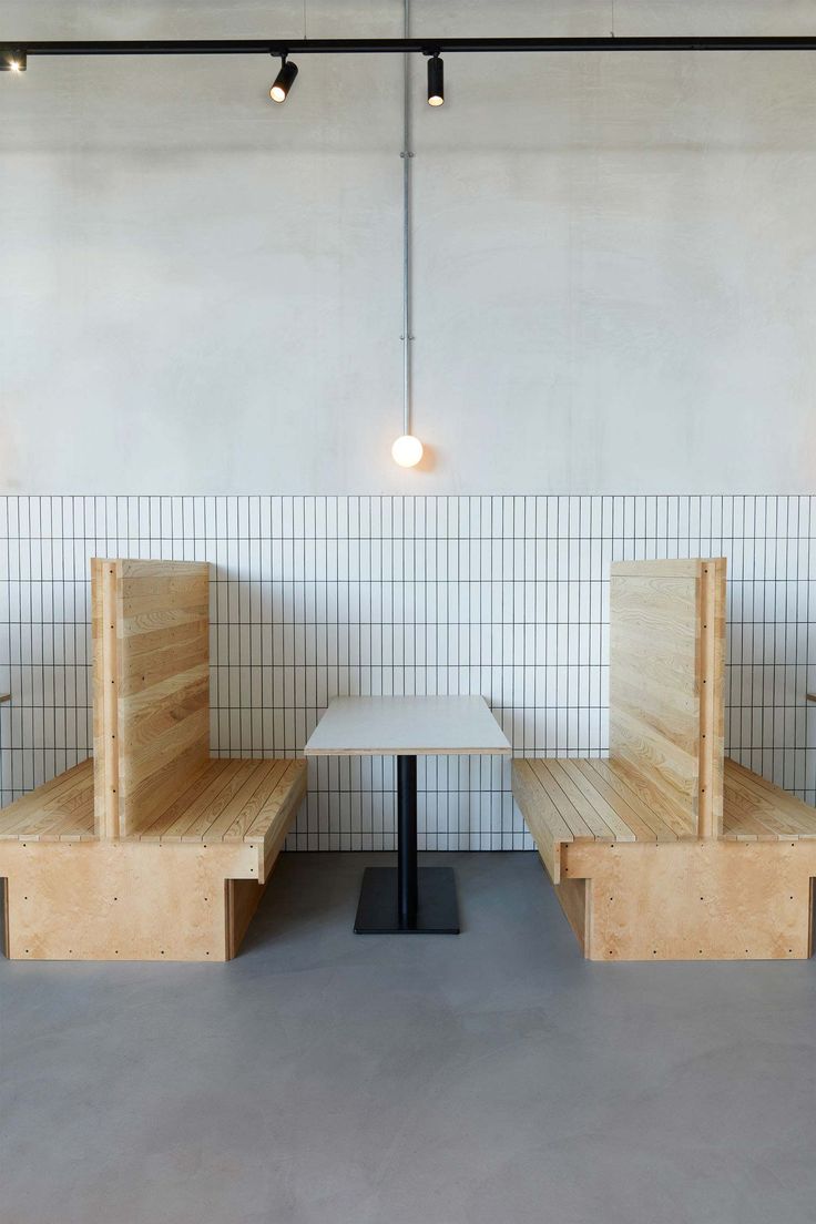 Inviting Minimalist Cafe Design: Wooden Booth Seating, Tiled Walls, and Ambient Lighting