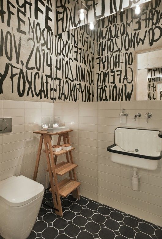 Modern Cafe Restroom Design Showcases Striking Black and White Aesthetic with Artistic Touches