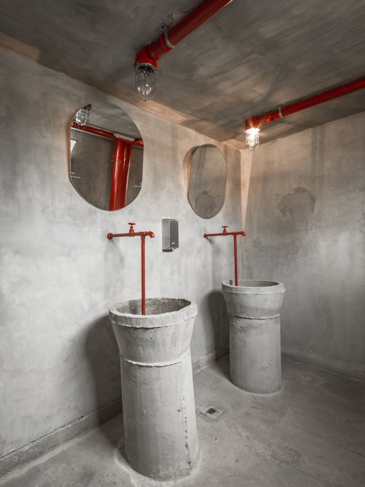 Modern Industrial Restroom Design Featuring Concrete Aesthetics and Striking Red Fixtures