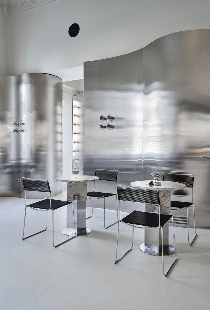 Modern Cafe Design: Striking Metallic Surfaces and Fluid Sculptural Elements Create a Chic Atmosphere