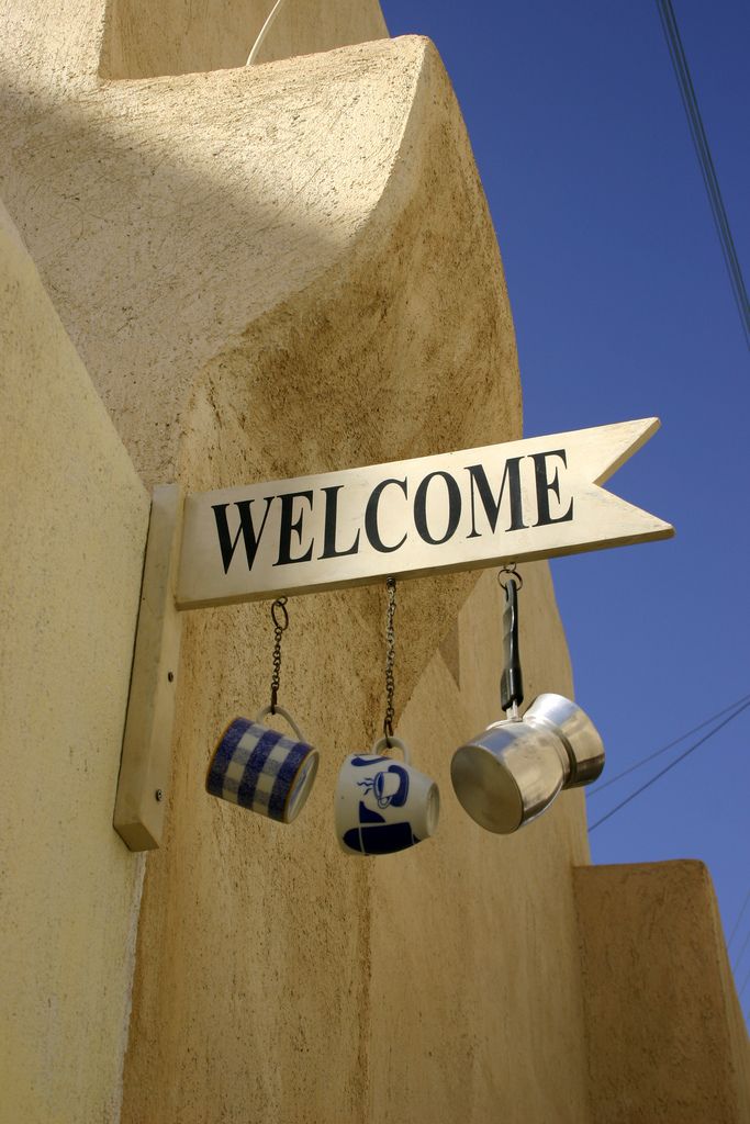 Charming Cafe Entrance with Rustic Sign and Inviting Atmosphere