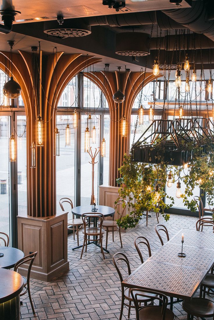 Modern Cafe Design: Harmonizing Natural Light, Elegant Archways, and Cozy Gatherings Amidst Lush Greenery