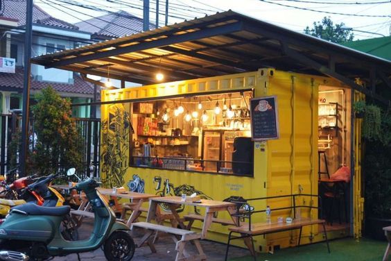 Inviting Cafe Design: A Bright Yellow Shipping Container Merging Modern Aesthetics with Rustic Charm