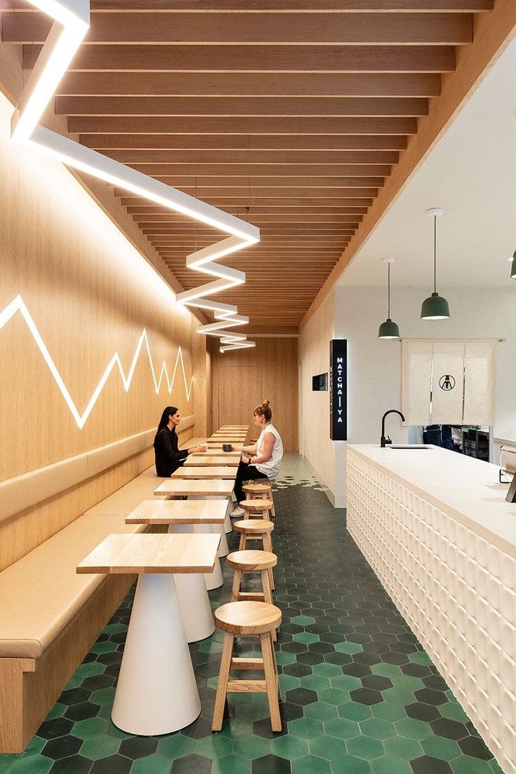 Modern Minimalist Cafe Design with Warm Wood, Zigzag Lighting, and Unique Hexagonal Flooring