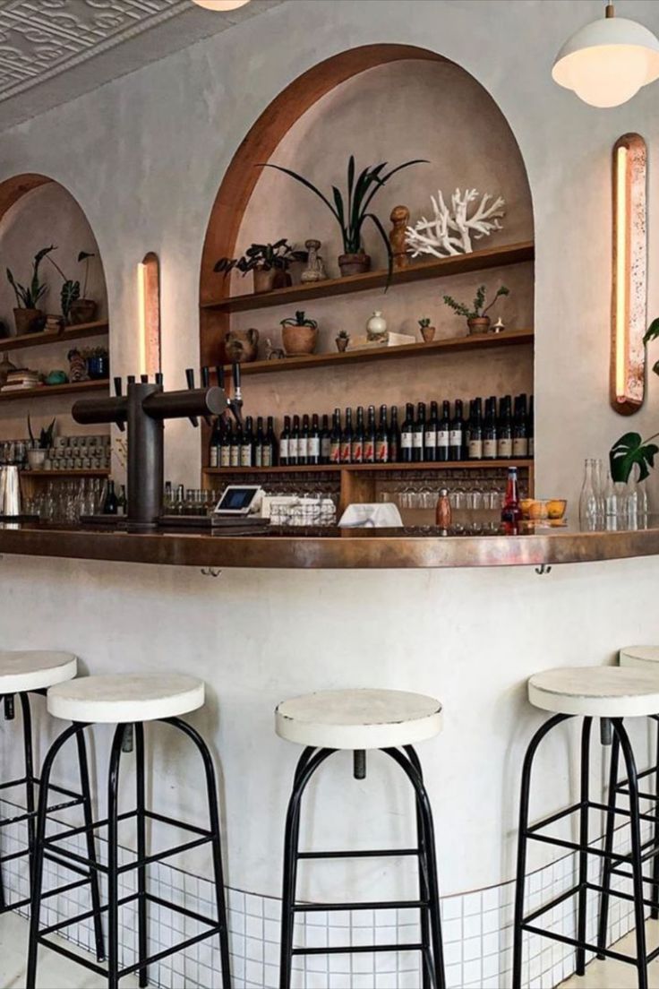 Stylish Cafe Design: Contemporary Rounded Bar with Natural Materials, Arched Shelves, and Minimalist Seating Create an Inviting Atmosphere