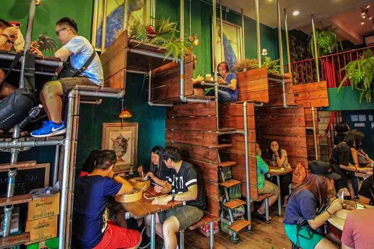 Trendy Cafe Design Blends Industrial Aesthetics with Lush Greenery for a Vibrant Social Atmosphere