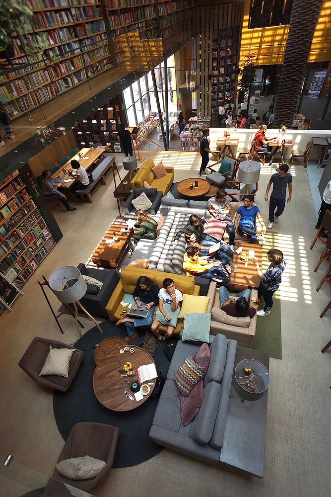 Inviting Cafe Design: Spacious Layout with Cozy Seating, Bookshelves, and Abundant Natural Light