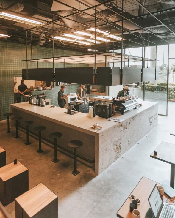 Modern Cafe Design: Open Layout with Minimalist Concrete Counter and Industrial Seating