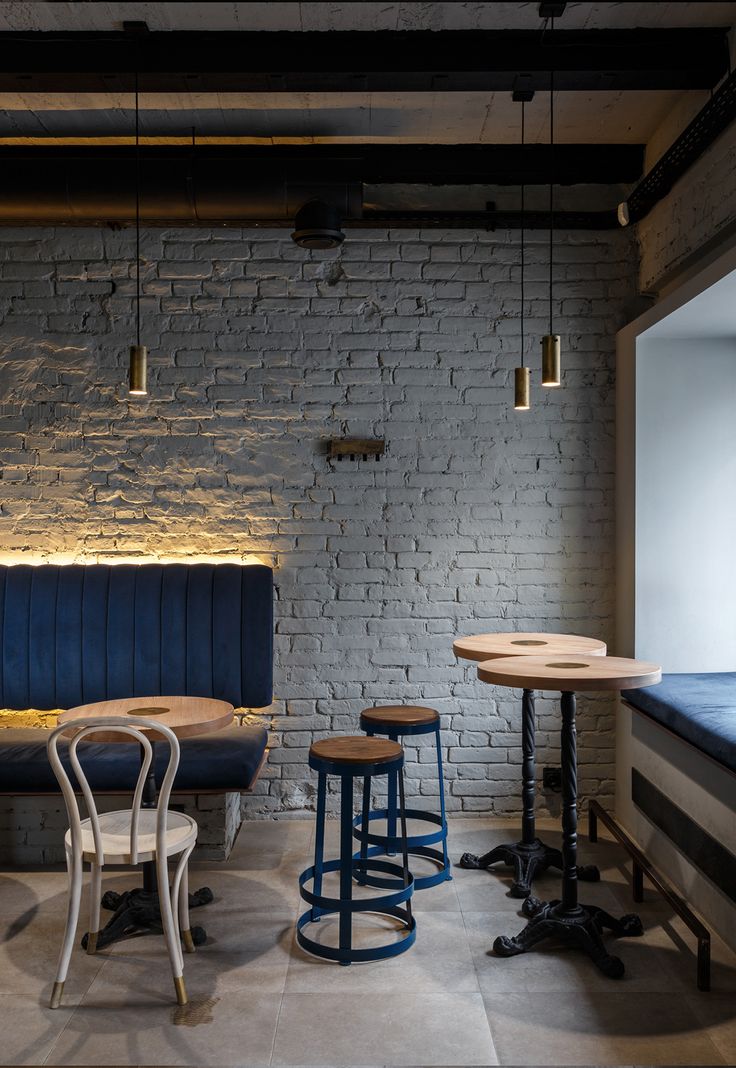 Modern Minimalist Cafe Design: An Inviting Space with Exposed Brick, Cozy Seating, and Warm Ambiance