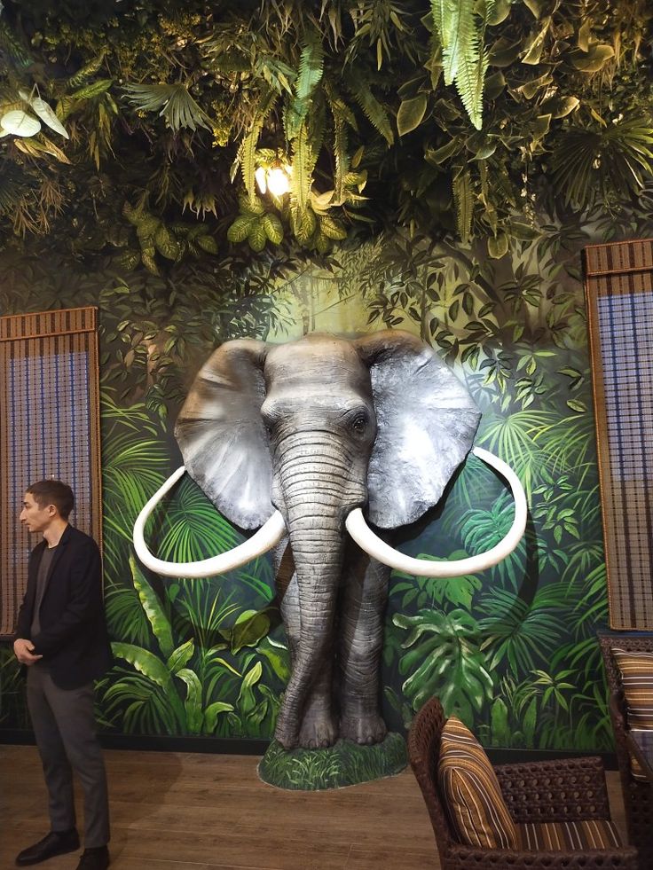 Vibrant Jungle Cafe with Oversized Elephant Sculpture and Tropical Decor