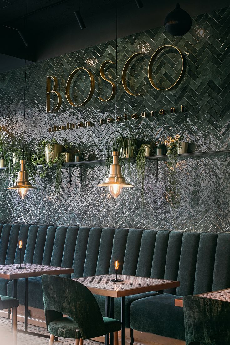 Modern Cafe Design: Elegant Atmosphere with Green Herringbone Tiles and Cozy Velvet Banquette