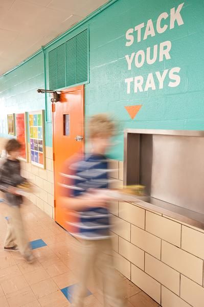 Vibrant Cafe Design with Turquoise Walls and Orange Accents Enhances Community Atmosphere