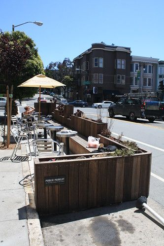 Cozy Outdoor Cafe Design with Wooden Privacy Barriers and Lush Planters