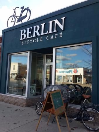 Modern Cafe Design: Inviting Deep Blue Facade with Cycling Theme and Airy Atmosphere