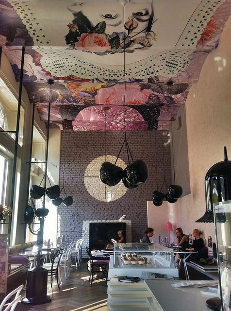 Elegant Cafe Design with High Ceilings, Artistic Murals, and Inviting Interiors