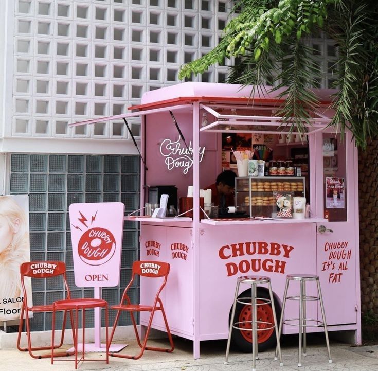 Playful Cafe Design Featuring a Vibrant Pink Food Truck and Inviting Outdoor Seating